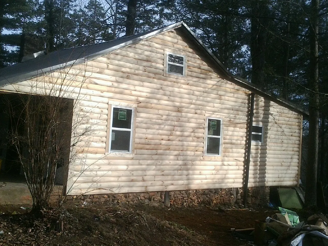 New log siding and dark metal roofing on a gable end in Mount Kisco