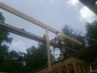Carpenter setting a ridge beam over a new addition frame — Ice Dam Removal by Roofing Brothers in Mount Kisco
