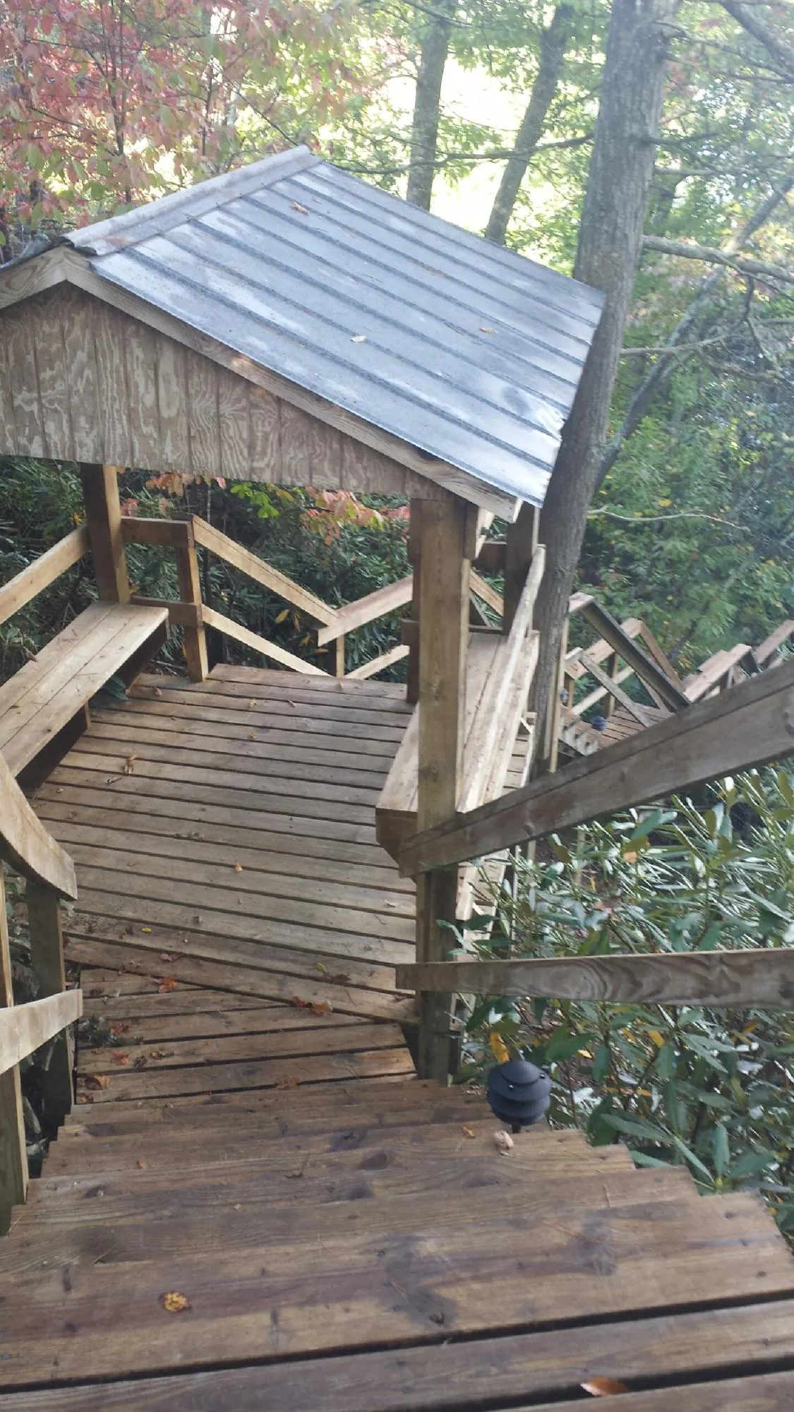 Metal roofed shelter over wooden steps on a wooded walkway — Skylight Repair & Installation work by our crew in Mount Kisco