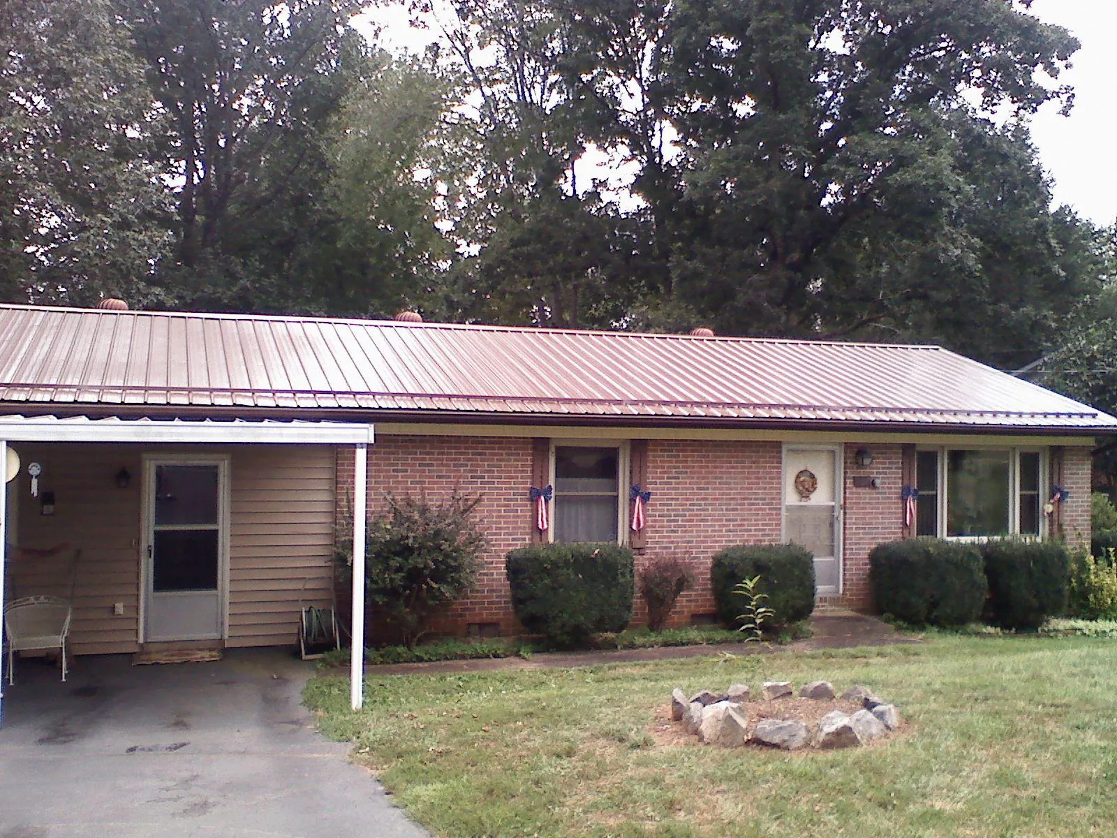 Bronze metal roof and carport on a brick ranch home — Roof Repair work by our crew in Mount Kisco